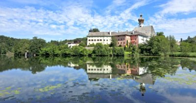 Blick über den Höglwörther See zum Kloster Höglwörth mit Spiegelungen im See